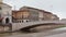 Tourists are crossing Ponte di Mezzo bridge connecting Piazza Garibaldi square and town hall of Pisa, Italy