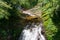 Tourists crossing rapid mountain river in Golden Stream ecotourism area,park in Vietnam