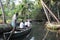 Tourists cruising on a canoe a river of the backwaters at Kollam