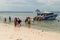 Tourists descend from the boat to the shore