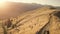 Tourists at dried grass, trees aerial. Mountain ranges at sunset. Sun setting. Nature landscape