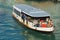 Tourists enjoy ride by the Vaporetto public transportation boat at Grand Canal in Venice, Italy.