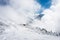 Tourists enjoying high mountains in snow on a sunny day