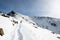 Tourists enjoying high mountains in snow on a sunny day