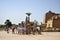 Tourists on excursions in Karnak Temple. Travel tour group near scarab beetle statue. Famous Egyptian landmark