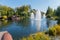 Tourists on excursions look at a small pond in delightful fountains in the middle