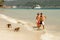 Tourists feeding crab-eating macaques at the beach on Phi Phi Do