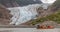 Tourists, a guide drifting in canoe by glacier