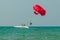 Tourists have fun, parachuting behind a boat, parasailing.