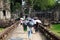 Tourists hiding under umbrellas see the sights. People with umbrellas. Medieval ruins