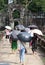 Tourists hiding under umbrellas see the sights. People with umbrellas. Medieval ruins