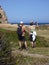 Tourists hikers taking photos in green meadow, bright spring morning, Sardinia, Italy