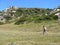 Tourists hikers walking in green meadow, bright spring morning, Sardinia, Italy