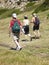 Tourists hikers walking in green meadow, Sardinia, Italy