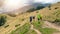 Tourists with hiking backpacks walk along a mountain trail. Background illustrating a healthy lifestyle