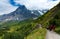 Tourists hiking on a trail by the grassy mountainside from Mannlichen to Kleine Scheidegg