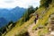 Tourists on hiking trails of picturesque Tegelberg mountain, a part of Ammergau Alps, located nead Fussen town, Germany.