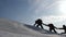 Tourists are holding hands climbing snowy mountain in Alaska. coordinated teamwork mountaineering in winter tourism in