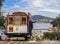 Tourists on the iconic cable car at the top of Hyde Street, overlooking the bay and Alcatraz prison, San Francisco, USA