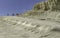 Tourists on impressive and steep limestone cliffs in Turks steps in Sicily on a blu sky day