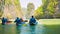 Tourists kayaking among limestone islands. Kayaking is a popular amusement for tourists