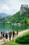 Tourists at the lakefront and Castle on the rock at the Bled Lake in Slovenia
