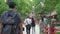 Tourists and local japanese people walk across the beautiful red bridge leading to the famous Tenmangu Shrine