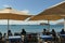 Tourists and locals have lunch in a typical tavern on the beach of Cape Sounio where the temple of Poseidon is located