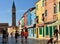 Tourists and locals walking through the beautiful town square of Burano, Italy. T