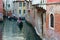 Tourists make romantic walk on gondolas along canals of Venice, Italy