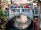 Tourists making photos on a bridge over channel in Venice, Italy