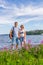 Tourists middle aged man and woman posing against beautiful landscape in summer sunny day. Couple standing on Ladoga lake shore.