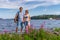 Tourists middle aged man and woman posing against beautiful landscape in summer sunny day. Couple standing on Ladoga lake shore.