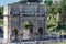 Tourists mill around the Arch of Constantine as seen from a view