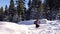 Tourists in the mountains in winter make their way through deep snow.