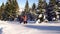 Tourists in the mountains in winter make their way through deep snow.