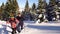 Tourists in the mountains in winter make their way through deep snow.