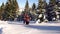 Tourists in the mountains in winter make their way through deep snow.