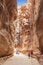 Tourists in narrow passage of rocks of Petra canyon in Jordan. Petra has been a UNESCO World Heritage Site since 1985