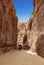 Tourists in narrow passage of rocks of Petra canyon in Jordan. Petra has been a UNESCO World Heritage Site since 1985.