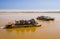 Tourists and off-road vehicles crossing Tsiribihina river on precarious handmade ferry boats