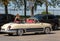 Tourists in an old beautifully preserved convertible in Saint Emilion. France.