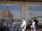 Tourists in the old town of florence, the famous cathedral Santa Maria del Fiore mirrors in a store window.