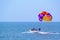 Tourists parasailing on Candolim Beach in Goa, India.