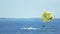 Tourists parasailing over sea, feet touching water, extreme sport, summer fun
