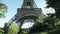 Tourists passing by the Eiffel tower in Paris, France