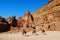 Tourists passing the Uneishu Tomb on the Street of Facades in Petra, Jordan