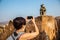 Tourists photograph the monkey Langur. She sits on the edge of the fortress wall
