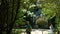 Tourists photograph the sculpture called Proteus and Glaucus at the Bomarzo Monster Park between trees and vegetation