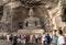 Tourists photography in front of iconic seated Buddha statue of Cave 20 at Yungang Grottoes